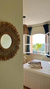 濱海聖西的住宿－HAMEAU DES AMANDIERS VUE MER - PISCINE, GOLF et TENNIS PRIVE，一间带镜子的卧室和一张带窗户的床