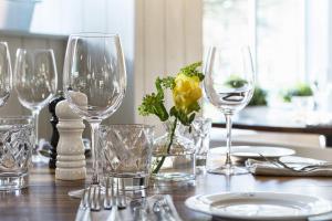a table with wine glasses and a yellow flower on it at The Old Stocks Inn in Stow on the Wold