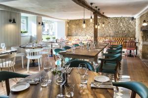 um restaurante com mesas de madeira e cadeiras verdes em The Old Stocks Inn em Stow on the Wold