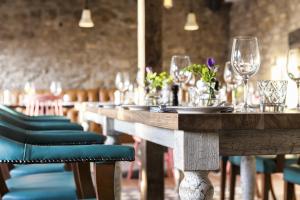 a long wooden table with chairs and wine glasses at The Old Stocks Inn in Stow on the Wold