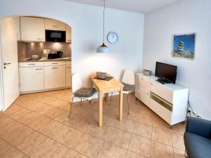 ein Wohnzimmer mit Tisch und Küche in der Unterkunft Villa Schwan in Binz - WG 19a "Kornblume" in Binz