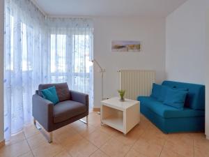 ein Wohnzimmer mit einem blauen Sofa und einem Sessel in der Unterkunft Villa Schwan in Binz - WG 19a "Kornblume" in Binz