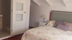 1 dormitorio con 1 cama con colcha de flores en Casas Isabel, en Zahora