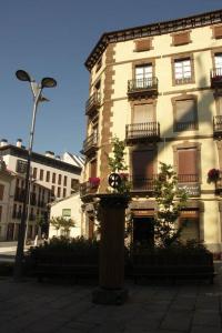 a tall building with a clock in front of it at Hostal Paris in Jaca