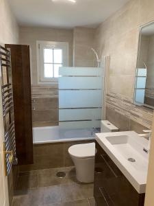 W łazience znajduje się toaleta, wanna i umywalka. w obiekcie El faro II Apartment con vista w mieście Huelva