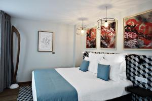 a hotel room with a bed with blue and white pillows at Boutique Hotel Villa du Taur in Toulouse +45 photos