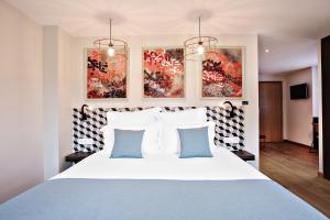 a bedroom with a bed with blue and white pillows at Logis Hôtel Villa du Taur in Toulouse