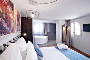 a bedroom with a large bed and a bath tub at Logis H&ocirc;tel Villa du Taur in Toulouse
