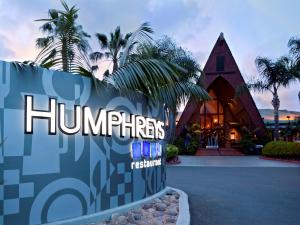 a sign in front of a resort with a building at Humphreys Half Moon Inn in San Diego