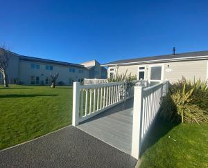 a wooden deck with a white fence in a yard at Croyde Bay Hotel or Self Catering in Croyde