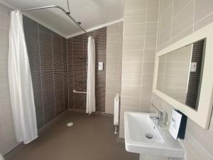 a white bathroom with a sink and a shower at Croyde Bay Hotel or Self Catering in Croyde