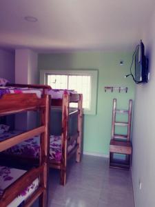 a room with three bunk beds and a television at FÁTIMA REAL in Ríohacha