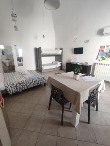a room with a table and chairs and a bedroom at La dimora di Roberto in Santeramo in Colle