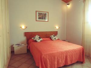 1 dormitorio con 1 cama con sábanas y almohadas de color naranja en Agriturismo Botro en Pulicciano