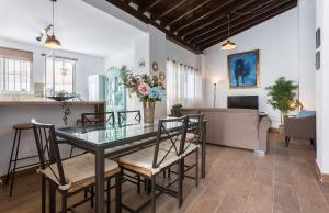 uma sala de jantar e sala de estar com uma mesa de vidro e cadeiras em San Miguel Terraza Tranquilo Moderno em Jerez de la Frontera