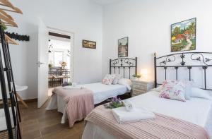um quarto com duas camas com lençóis cor-de-rosa e brancos em San Miguel Terraza Tranquilo Moderno em Jerez de la Frontera
