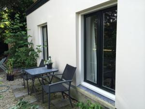 una mesa y sillas en un patio junto a una ventana en Bed&Brood Comon en Ubbergen