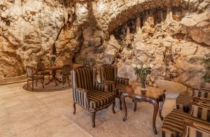 a room with chairs and a table in a stone wall at Hotel Bellevue - Liburnia in Opatija