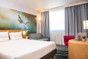 um quarto de hotel com uma cama e uma secretária em Novotel Marne La Vallée Collégien em Collégien