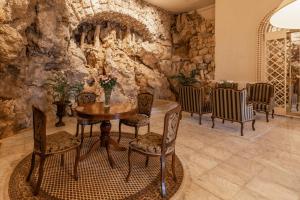 a dining room with a stone wall and a table and chairs at Hotel Bellevue - Liburnia in Opatija
