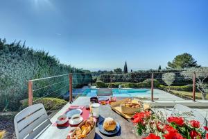 een tafel met eten naast een zwembad bij The View Aix-en-Provence in Aix-en-Provence
