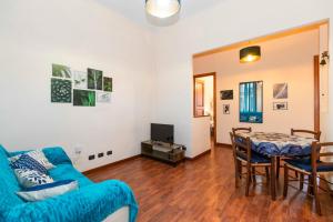 un soggiorno con un divano blu e un tavolo di Piazza Statuto Comfy APT - with 2 Balconies a Torino