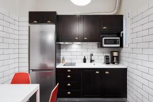a kitchen with black cabinets and a stainless steel refrigerator at Acropolis Prestige Residence in Athens