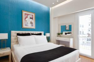 1 dormitorio con 1 cama grande y paredes azules en Acropolis Prestige Residence en Atenas