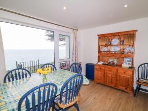 a dining room with a table and chairs and a window at Rocklea Seaside Cottage in Newcastle