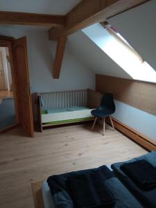una camera con un letto e una sedia di Ferienwohnung Schaeferhof, die Natur vor der Haustüre a Cottbus