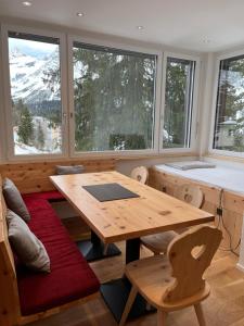 a dining room with a table and some windows at Zum Rota Hus in Arosa