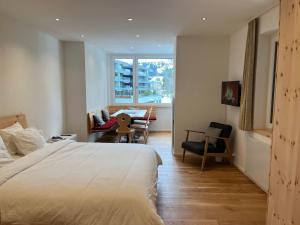 a bedroom with a bed and a desk and a chair at Zum Rota Hus in Arosa