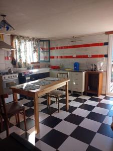 cocina con mesa y suelo a cuadros en Casa de huéspedes La vista en El Hoyo