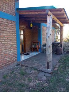 un porche de una casa de ladrillo con un poste de madera en Casa de huéspedes La vista en El Hoyo
