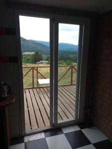 una puerta corredera de cristal con vistas a una terraza de madera en Casa de huéspedes La vista en El Hoyo