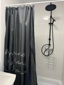 a shower curtain with the words shine a light in a bathroom at Noclegi Mosina in Mosina