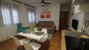 sala de estar con sofá, mesa y sillas en Elisa Home, en Toledo