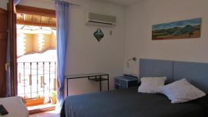 a bedroom with a bed and a large window at Hostal de la Luz in Cuenca