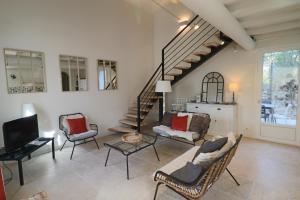una sala de estar con muebles y una escalera. en Le mas Sainte Marie en Venasque