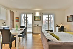 una camera con letto, tavolo e sedie di CaseOspitali - Casa Kikka elegante appartamento con balcone in nuovo condominio a Cernusco sul Naviglio