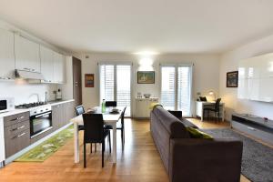 una cucina e un soggiorno con un divano e un tavolo di GuestHost - Casa Kikka luminoso bilo con balcone a Cernusco sul Naviglio Altre 19 foto