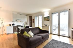 un soggiorno con divano e cucina di GuestHost - Casa Kikka luminoso bilo con balcone a Cernusco sul Naviglio