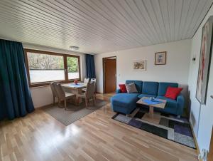 sala de estar con sofá azul y mesa en B1 Albmatte-FEWO Sauna, Hallenbad Außenbecken Massagen nebenan, en Menzenschwand