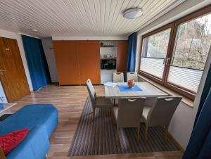 comedor con mesa y sofá azul en B1 Albmatte-FEWO Sauna, Hallenbad Außenbecken Massagen nebenan, en Menzenschwand