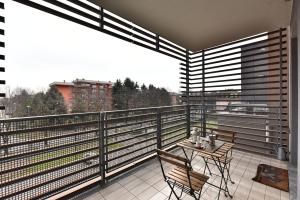 balcone con tavolo e sedie. di CaseOspitali - Casa Kikka elegante appartamento con balcone in nuovo condominio a Cernusco sul Naviglio