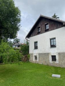 ein großes weißes Gebäude mit Fenstern auf einem Hof in der Unterkunft Chata Pepina in Růžová