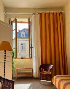 um quarto com uma janela, uma cama e uma janela em Maison Sainte Barbe em Autun