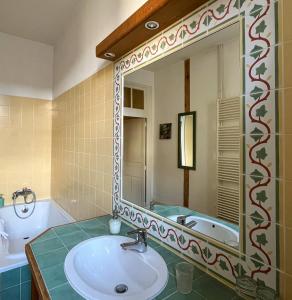 a bathroom with a sink and a large mirror at Maison Sainte Barbe in Autun