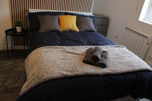 a bed with a blanket and a pair of shoes on it at Superb Studio Flats in City Centre in Southampton