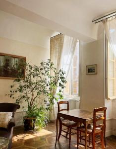 uma sala de jantar com uma mesa e um vaso de plantas em Maison Sainte Barbe em Autun